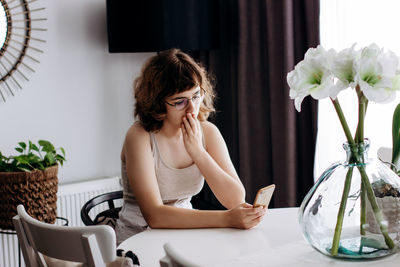 Woman sitting on table at home