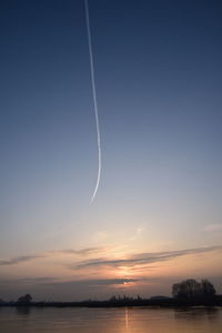 Scenic view of vapor trails in sky during sunset