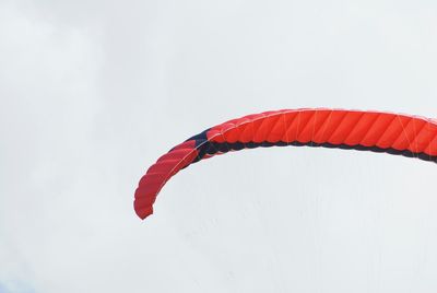 Low angle view of paragliding against sky