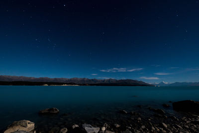 Scenic view of lake against sky at night