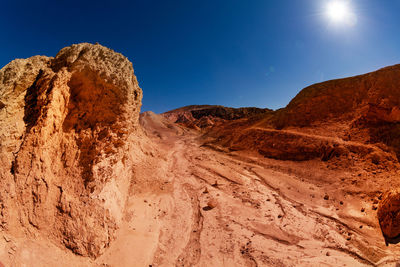 Rock formations on landscape against clear blue sky