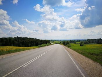 Empty road along landscape and against sky