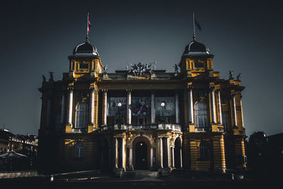 Low angle view of illuminated building against sky at night