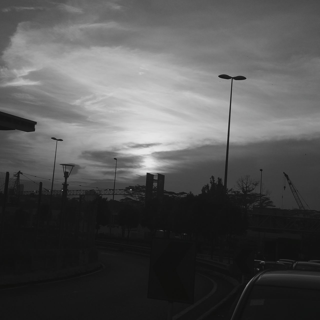 street light, sky, building exterior, silhouette, transportation, built structure, car, street, cloud - sky, lighting equipment, road, architecture, city, sunset, dusk, land vehicle, cloudy, mode of transport, outdoors, cloud