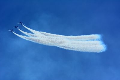 Low angle view of airplane flying against blue sky