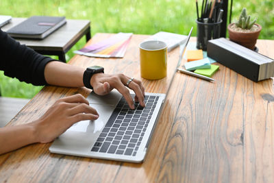 Midsection of man using laptop on table