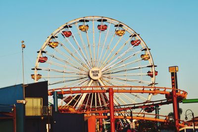 Low angle view of ferris wheel against clear sky