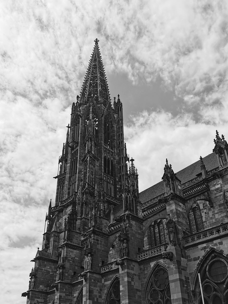 architecture, built structure, building exterior, sky, building, black and white, travel destinations, religion, spire, place of worship, history, low angle view, the past, belief, cloud, tower, spirituality, monochrome, landmark, monochrome photography, travel, worship, nature, tourism, city, no people, gothic style, day, outdoors, catholicism, steeple