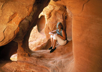 Full length of woman sitting in cave