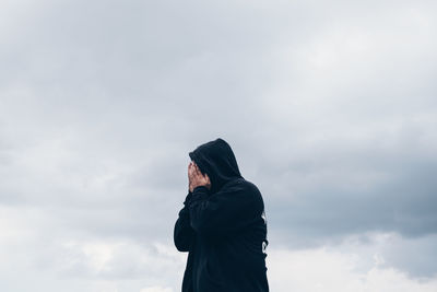 Rear view of man standing against sky