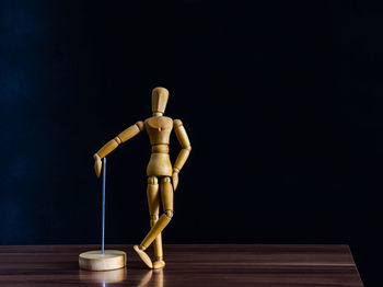 Statue of figurine on table against black background