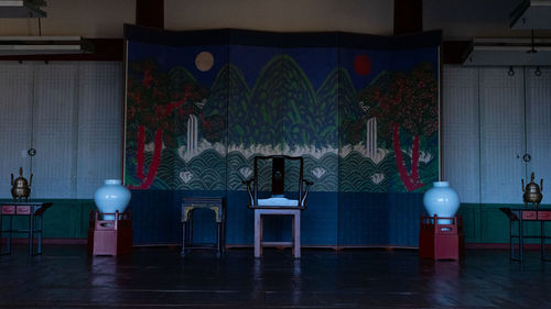 Empty chairs and tables in illuminated building