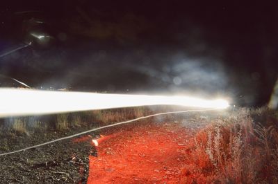 Close-up of illuminated road against sky at night