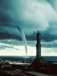 Lighthouse by sea against sky