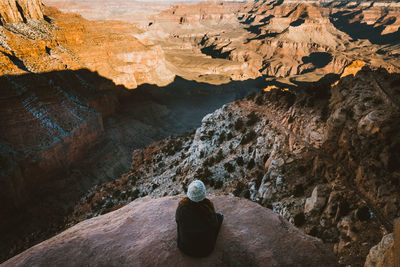 Rear view of man on rock in cave