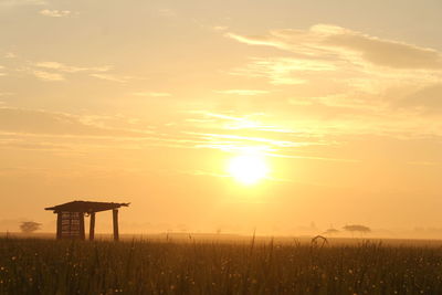 Scenic view of field against sky during sunset