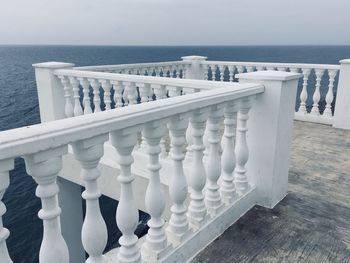 Railing by sea against sky