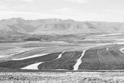 Scenic view of road by mountains against sky