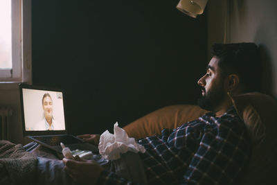 Portrait of young man looking away at home