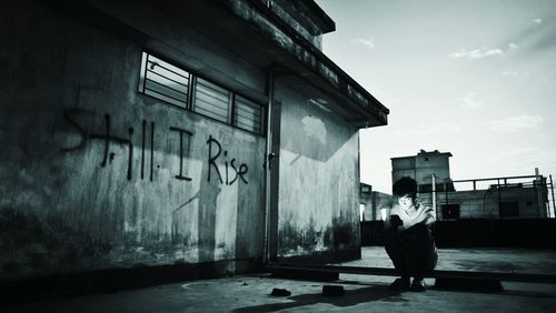 Young man using mobile phone on terrace against sky at night