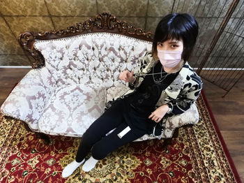 High angle portrait of girl sitting on floor at home