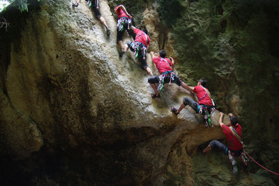 Low angle view of men climbing on rock formation