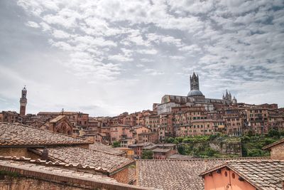 Buildings against cloudy sky