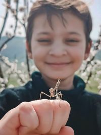 Close-up of cute boy holding mantis