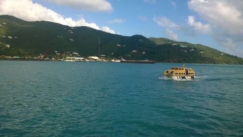 Boats in sea with mountains in background