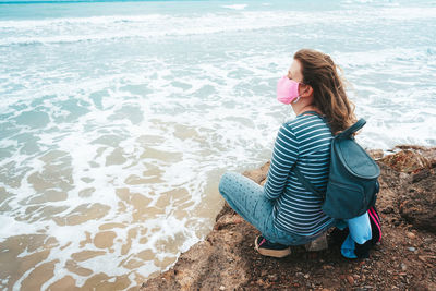 Young woman sitting on shore at beach