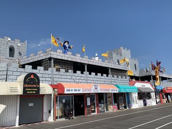 People in city against clear blue sky