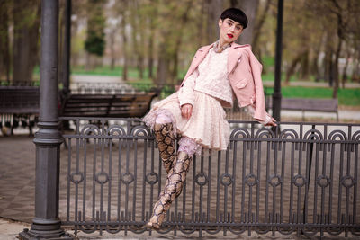 Portrait of woman against pink fence