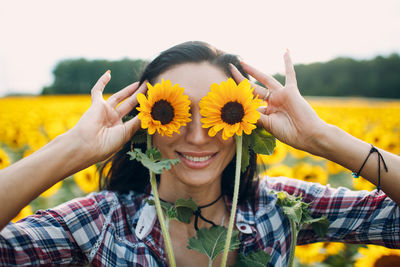 Portrait of smiling young woman with sunflower