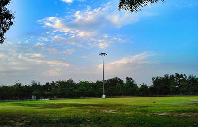 Scenic view of grassy field against cloudy sky