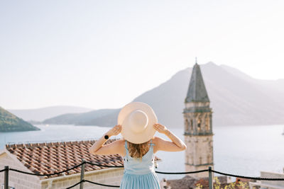 Rear view of woman wearing hat against sky