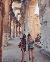 Full length of woman standing at historical building