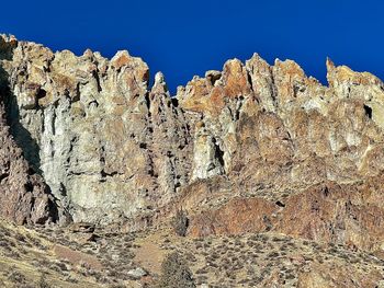 Low angle view of rocks against blue sky