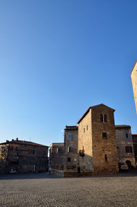 Low angle view of buildings against clear blue sky