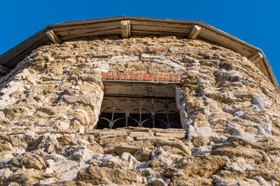 Low angle view of old building against clear blue sky