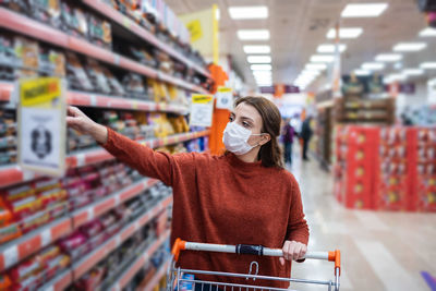 Full length of woman wearing mask at store