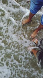 Low section of man standing in water