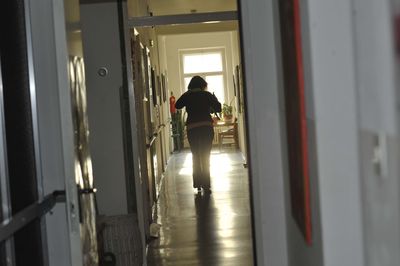 Rear view of man walking in corridor of building