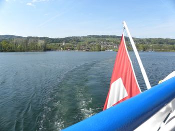 Sailboat in lake against blue sky