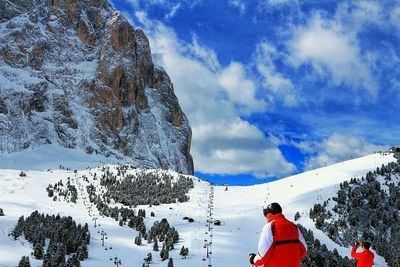 Rear view of person standing on snow covered mountain