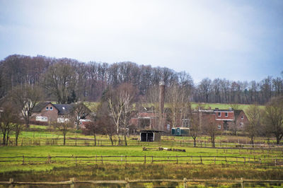 Houses on field against clear sky