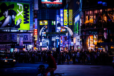 People walking on city street at night