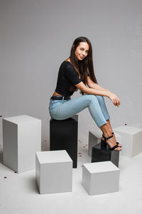 Portrait of young woman against wall