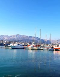 Sailboats in sea against clear blue sky