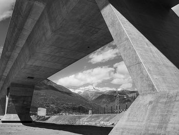 View of below bridge against cloudy sky