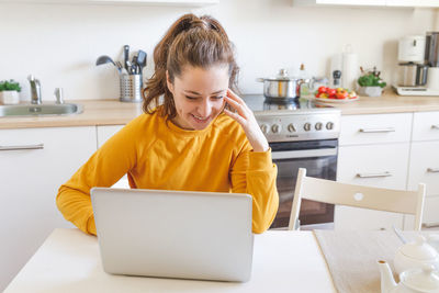 Boy using laptop while sitting on table